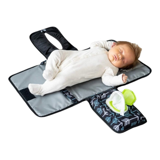 Bebé durmiendo sobre cambiador portátil plegable Acüchichi con estampado de flechas, superficie impermeable y gris.