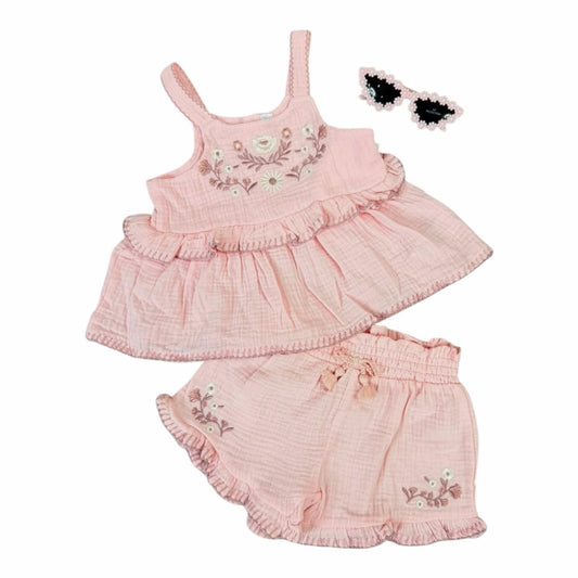 Conjunto Acüchichi de blusa y short rosa en muselina de algodón con bordados florales, volantes y lentes de sol.