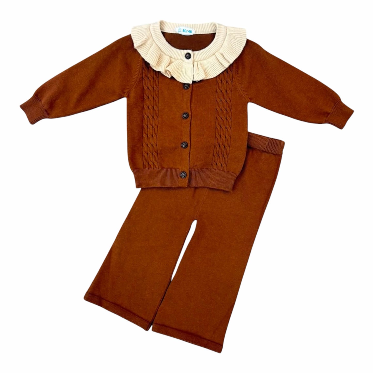 Conjunto de dos piezas Acüchichi color marrón con cárdigan de punto, cuello con volantes crema y pantalón a juego.