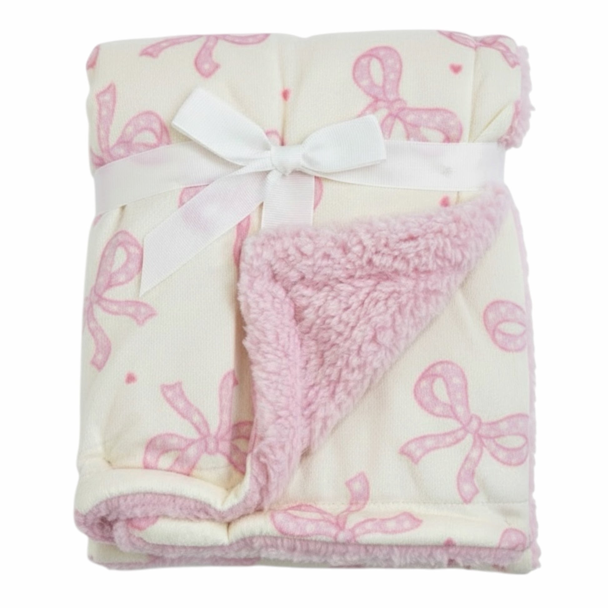 Manta Acüchichi para bebé con estampado de lazos rosas sobre fondo crema y reverso de suave borreguito rosa.